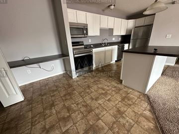 Rochester apartment for rent - a kitchen with white cabinets and stainless steel appliances