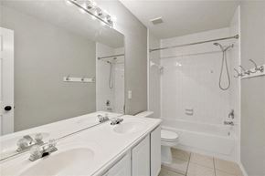 Pearland house for rent - A white bathroom with a double sink vanity and a walk-in shower.