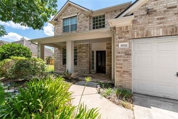 Pearland house for rent - A house with a white garage door and a brick facade.
