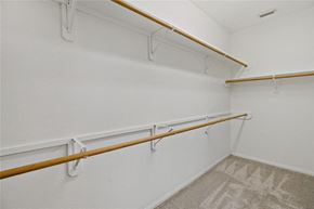 Pearland house for rent - A white wall with a row of shelves and a carpet on the floor.