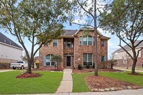 Rosharon house for rent - A house with a brick facade and a large front yard.