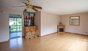 Moorhead apartment for rent - A room with a ceiling fan and wooden floors.