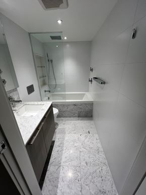 Vancouver apartment for rent - A white bathroom with a marble floor and a walk-in shower.