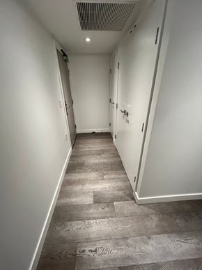Vancouver apartment for rent - A long, narrow hallway with wood flooring and white walls.
