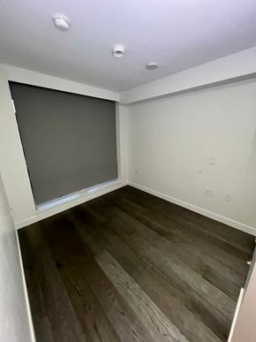 Vancouver apartment for rent - A room with a wooden floor and a grey screen door.