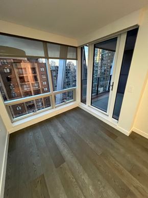 Vancouver apartment for rent - A room with a view of a cityscape through large windows.