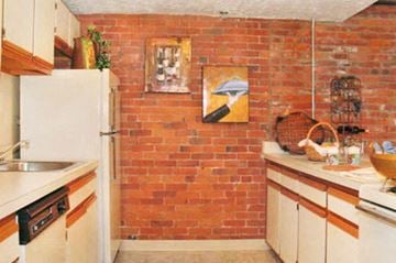 Vernon apartment for rent - a kitchen with a brick wall and a white refrigerator