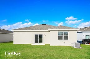 Bartow house for rent - a beige house with a grass yard and a blue sky