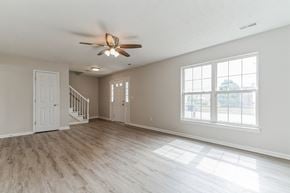 Louisville house for rent - an empty living room with a ceiling fan and a window