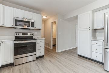 Louisville house for rent - a renovated kitchen with white cabinets and stainless steel appliances