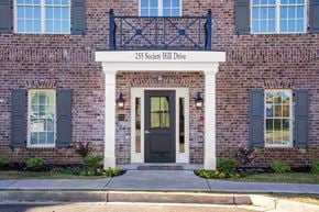 Aiken apartment for rent - A brick building with a black door and windows with shutters.