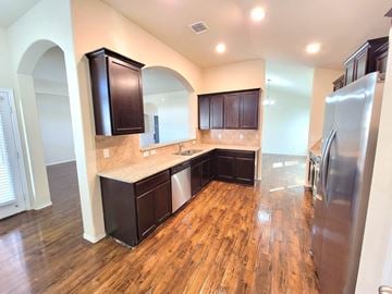 Killeen house for rent - a kitchen with wooden floors and a stainless steel refrigerator