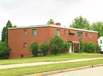 Bedford apartment for rent - a red brick building with a sidewalk and grass