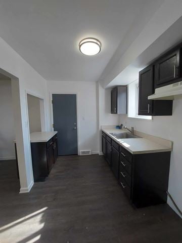 Bedford apartment for rent - A kitchen with black cabinets and a white countertop.