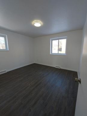 Bedford apartment for rent - A room with wooden floors and two windows.