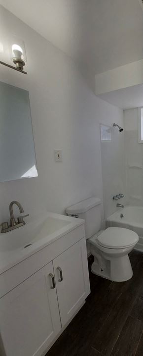 Bedford apartment for rent - A white toilet sits next to a white sink in a bathroom.