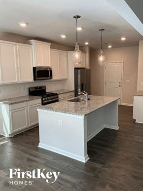 Greenville house for rent - an updated kitchen with white cabinets and granite counter tops