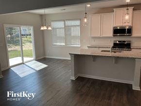 Greenville house for rent - a kitchen with white cabinets and a marble counter top