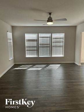 Greenville house for rent - an empty living room with wood floors and a ceiling fan
