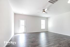 Greenville house for rent - A spacious room with wooden floors and a ceiling fan.