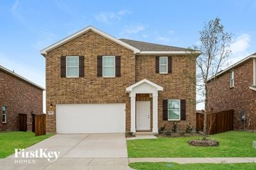 Forney house for rent - a brick house with a white garage door and a lawn
