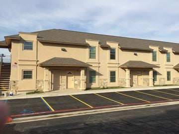Laredo apartment for rent - a large building with three entrances and a parking lot