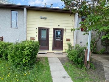 Prince Albert house for rent - the front of a house with two doors and a sidewalk