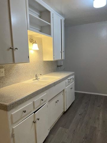 Calimesa apartment for rent - a kitchen with white cabinets and a counter top and a sink