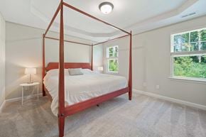 Jacksonville house for rent - A bedroom with a four-poster bed and a small table with a lamp.