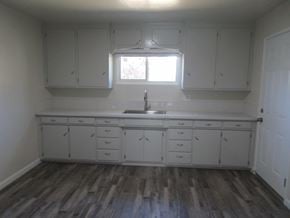 Patterson house for rent - A kitchen with white cabinets and a wooden floor.