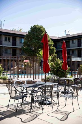 Orem apartment for rent - a patio with tables and chairs and umbrellas near a pool