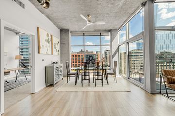 Denver apartment for rent - an open living room with a dining room table and a view of the city