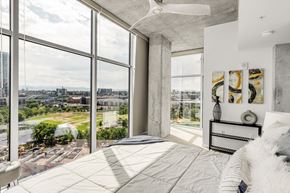 Denver apartment for rent - a bedroom with a view of a city and a bed and a large window