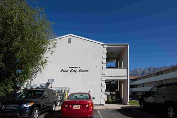 Orem apartment for rent - a white building with cars parked in front of it