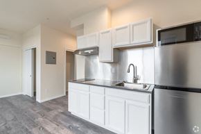 Seattle apartment for rent - an empty kitchen with white cabinets and stainless steel appliances