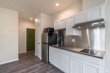 Seattle apartment for rent - a kitchen with white cabinets and a stainless steel refrigerator