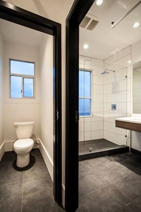 Vancouver apartment for rent - A bathroom with a toilet, a walk-in shower, and a window.