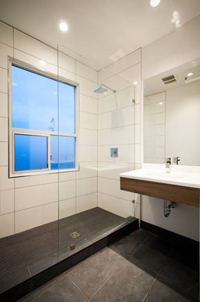 Vancouver apartment for rent - A modern bathroom with a large mirror and a window.