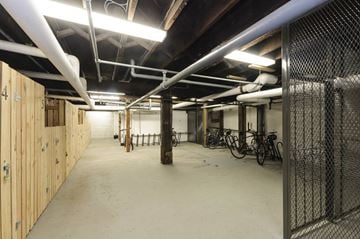 Vancouver apartment for rent - A spacious garage with wooden walls and a concrete floor.