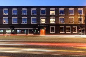 Vancouver apartment for rent - A Hampton hotel is shown at night with light streaks in the foreground.