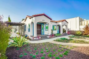 Los Angeles apartment for rent - A white house with a red tile roof and a blue door.