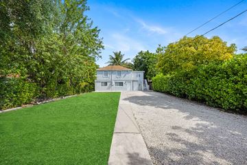 Miami apartment for rent - A house with a green lawn and trees in the background.