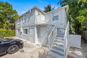 Miami apartment for rent - A two-story house with a car parked in front.