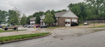 Kearney apartment for rent - A parking lot with cars and a building in the background.