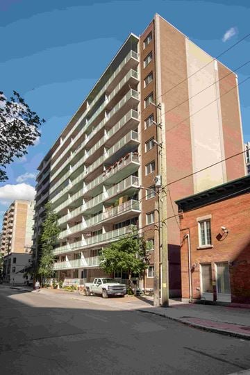 Ottawa apartment for rent - A tall apartment building with balconies on the second floor.
