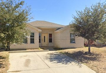 Laredo house for rent - a white brick house with a tree and a sidewalk
