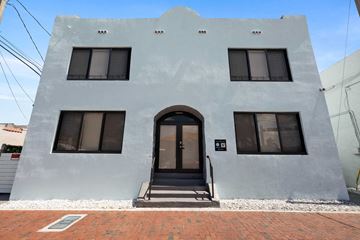 Miami apartment for rent - the front of a white building with a door and windows