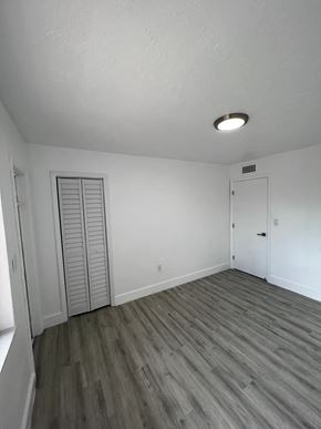 Miami apartment for rent - A room with a sliding door and a wooden floor.
