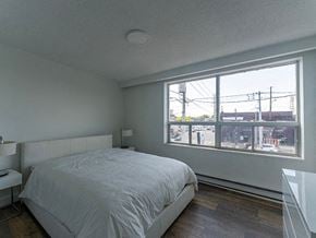 Toronto apartment for rent - a white bedroom with a large window and a white bed
