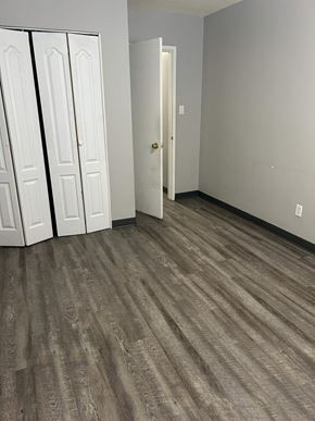 Edmonton apartment for rent - A room with a white door and a white closet with a black stripe down the middle.